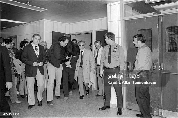 New York City police officers escort Mark David Chapman after his arrest for the murder of John Lennon, New York, New York, December 8, 1980.