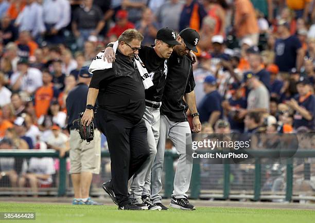 Chicago White Sox center fielder Charlie Tilson , center, is being help by athletic trainer Herm Schneider, left, and manager Robin Ventura in the...