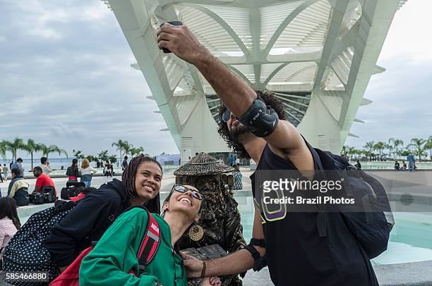Young people take selfies with a living statue in front of The Museum of Tomorrow , a science museum in the city of Rio de Janeiro, Brazil, designed...