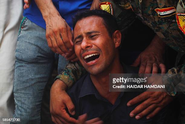 An Iraqi man mourns over the coffins of Shiite students who were killed in the Khalidiyah area of Iraq's Anbar province fighting alongside...