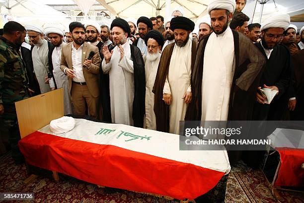 Iraqi Shiite clerics and mourners pray next to the coffins of Shiite students who were killed in the Khalidiyah area of Iraq's Anbar province...