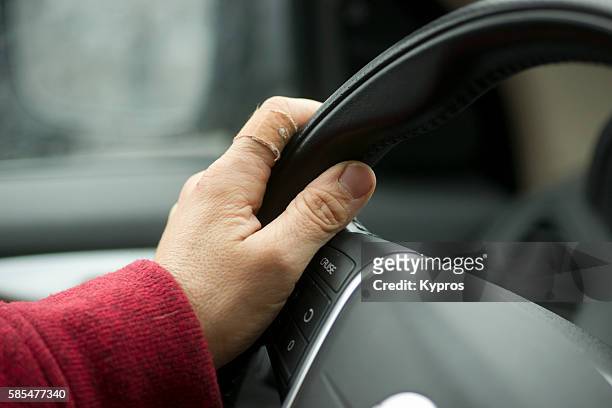 europe, germany, bavaria, view of senior woman driving car, close-up of hand holding steering wheel - frau fotografías e imágenes de stock