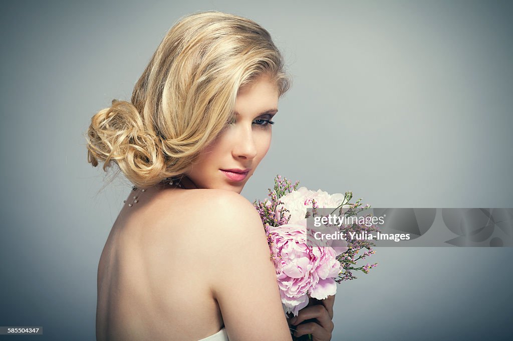 Bride with bare shoulders holding bouquet