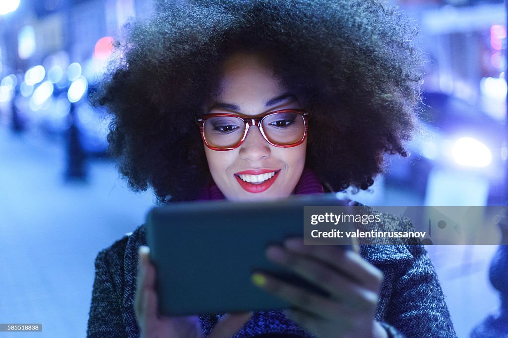 Bellissima giovane donna utilizzando talea digitale di notte