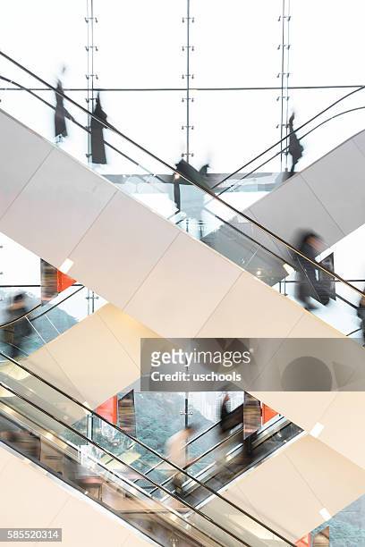 moderne rolltreppe mit verschwommenen menschen - pedestrian walkway stock-fotos und bilder