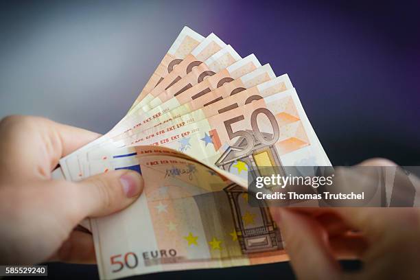 Berlin, Germany In this Photo Illustration a person holds Euro banknotes on August 03, 2016 in Berlin, Germany.