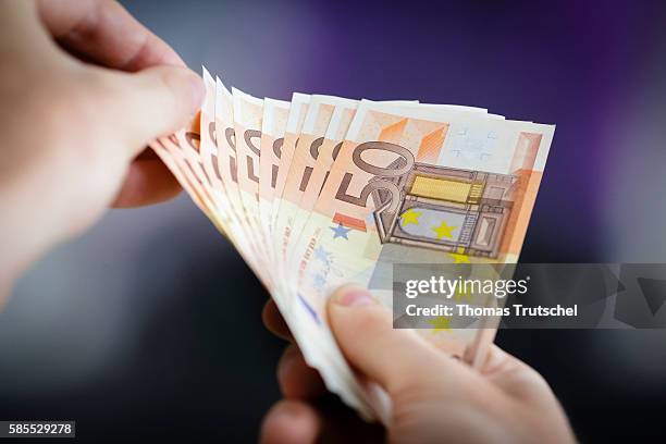 Berlin, Germany In this Photo Illustration a person holds Euro banknotes on August 03, 2016 in Berlin, Germany.