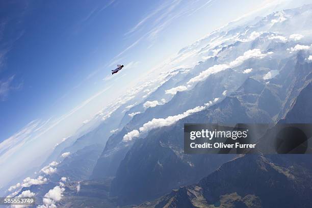 wingsuit skydiver pilot lost in the sky - wing suit stock pictures, royalty-free photos & images