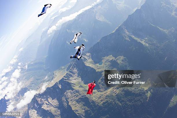 wingsuit skydivers are flying above each other - wing suit stock pictures, royalty-free photos & images