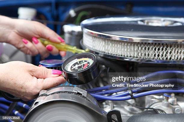 a woman tuning a car engine with a vacuum gauge - car tuning stock pictures, royalty-free photos & images