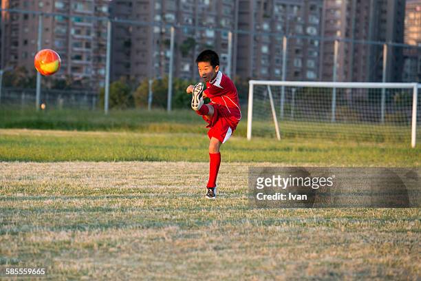 a boy play soccer game in a field - trefferversuch stock-fotos und bilder