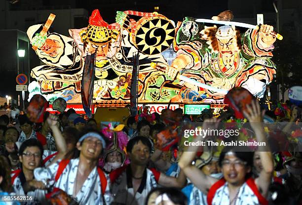 People marach on with 'Nebuta' floats as the Aomori Nebuta Festival begins on August 2, 2016 in Aomori, Japan.