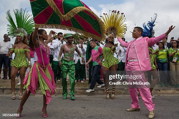 Dancers from the Mangueira samba school dance in the street while waiting for the arrival of the Olympic flame ahead of the Rio 2016 Olympic Games on...