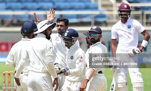 India bowler Ravichandran Ashwin celebrates with teammates after his delivery to West Indies batsman Jermaine Blackwood was caught out by Cheteshwar...