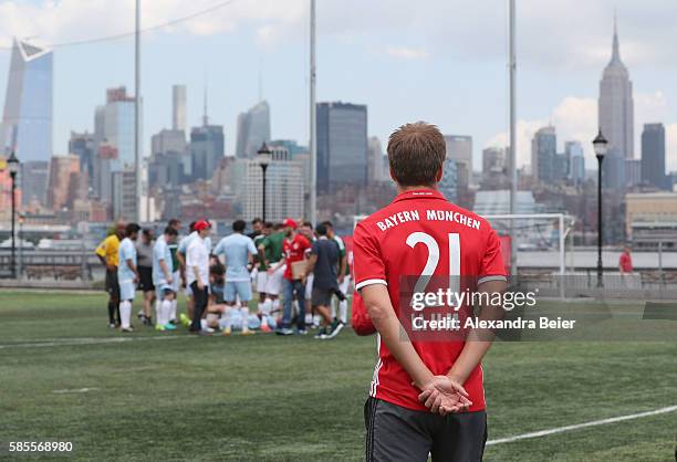 Philipp Lahm of FC Bayern Muenchen watches a soccer tournament played by FC Bayern Muenchen U.S. Fan clubs in front of New York's skyline during the...