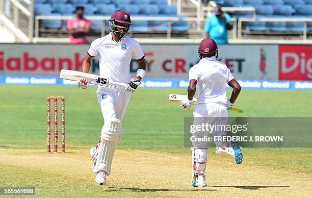 West Indies batsmen Roston Chase and Jermaine Blackwood score a run off a delivery from bowler Mohammed Shami of India on day five of their Second...