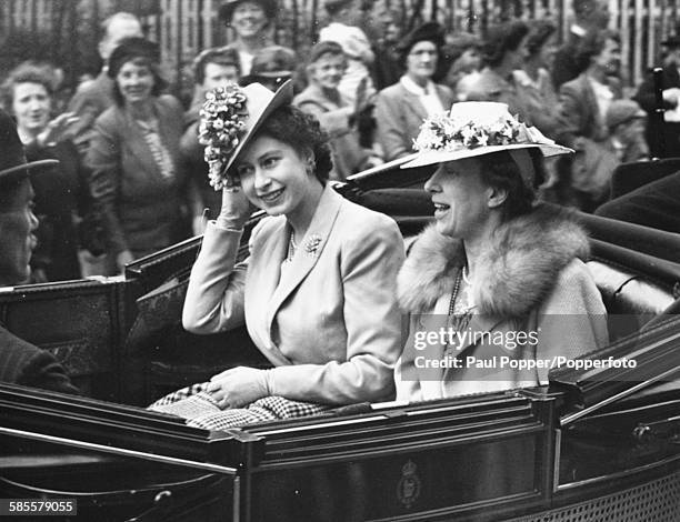 Princess Elizabeth and her aunt Mary, Princess Royal, ride together in an open carriage to the first Royal Ascot race meeting since World War Two,...