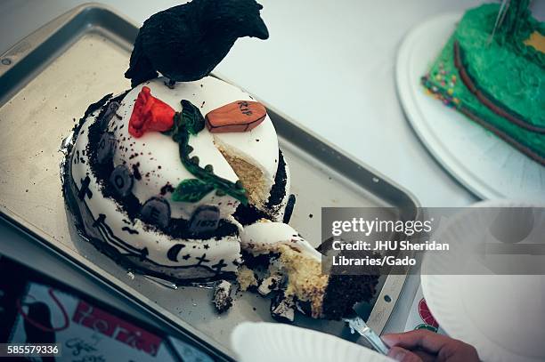 Knife cutting a slice out of a cake with a coffin, a rose, and a raven on it representing stories by Edgar Allan Poe in the Edible Book Festival at...