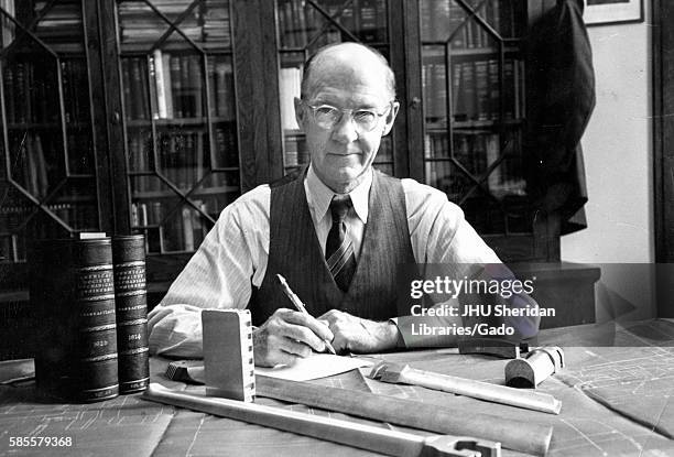 Professor of engineering at Johns Hopkins University Alexander Graham Christie sitting at his desk with a book shelf behind him, Baltimore, Maryland,...