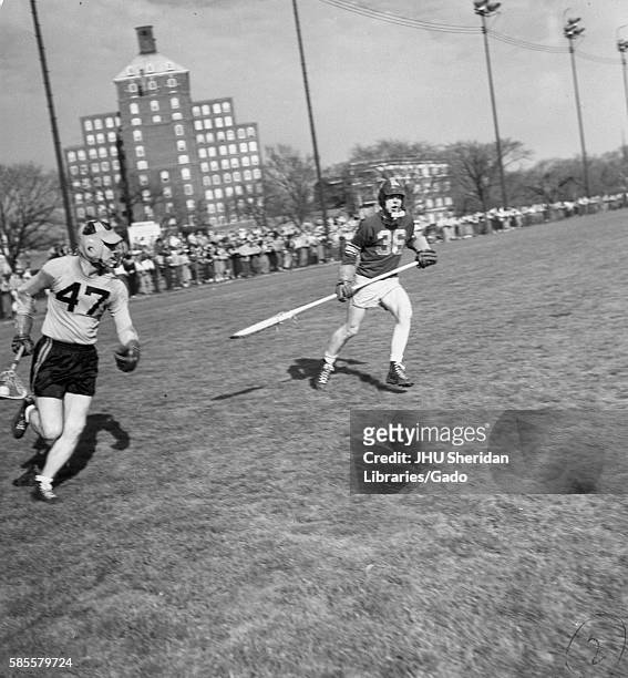 During a lacrosse game, a Loyola defenseman goes for Johns Hopkins Co-captain and attackman Byron Forbush , on the Homewood Field in Baltimore,...