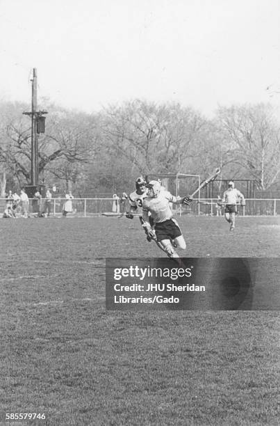 Players on a field during an N.C.A.A. Division one lacrosse game, in which one team was Johns Hopkins University, 1975. .