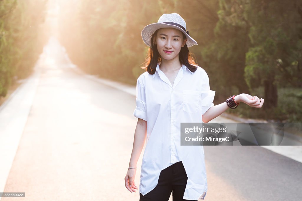 Young Girl Standing on Road in Sunset Glow