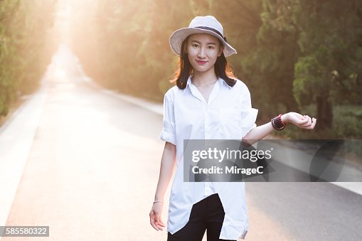 Young Girl Standing on Road in Sunset Glow Young Girl Standing on Road in Sunset Glow