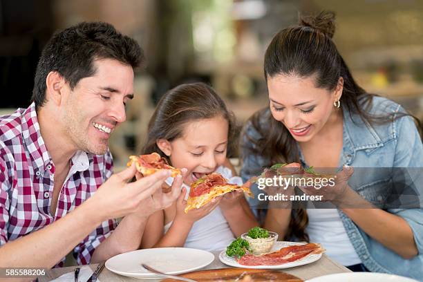 happy family eating pizza at a restaurant - pizza restaurant stock pictures, royalty-free photos & images
