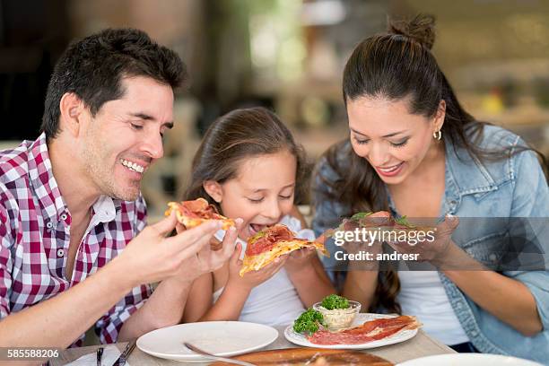 happy family eating pizza at a restaurant - kid eating restaurant stock pictures, royalty-free photos & images