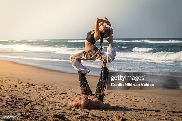 couple doing acroyoga on beach - durban stock pictures, royalty-free photos & images
