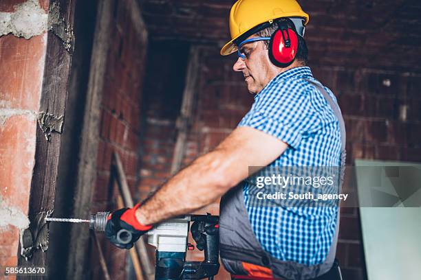 male construction worker with a drill - punching wall stock pictures, royalty-free photos & images