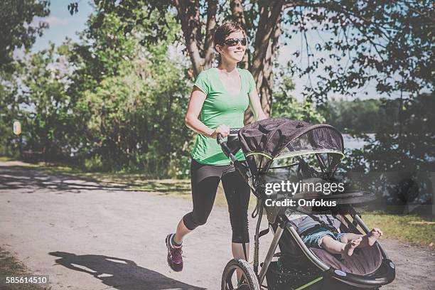 mother running walking with baby stroller in park - baby pram in the park bildbanksfoton och bilder