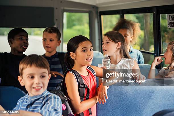 Group of elementary age kids in a school bus.