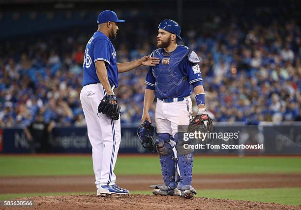 Russell Martin of the Toronto Blue Jays visits Franklin Morales on the mound in the twelfth inning during MLB game action against the Baltimore...