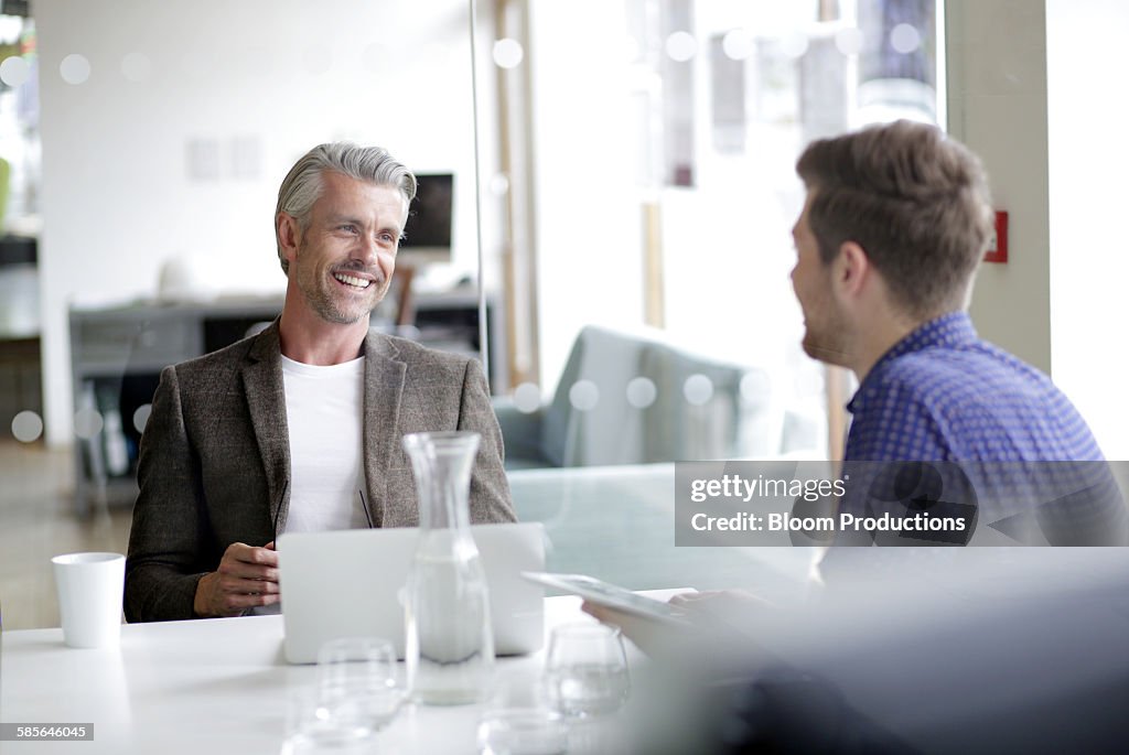 Two colleagues laughing in a modern office