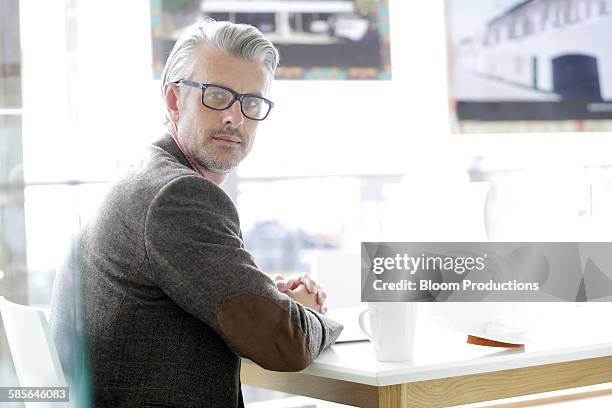 portrait of an architect in a modern office - looking over shoulder photos et images de collection