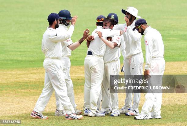 Bowler Amit Mishra of India is congratulated by teammates after bowling out Shane Dowrich of the West Indies on an LBW on day five of their Second...