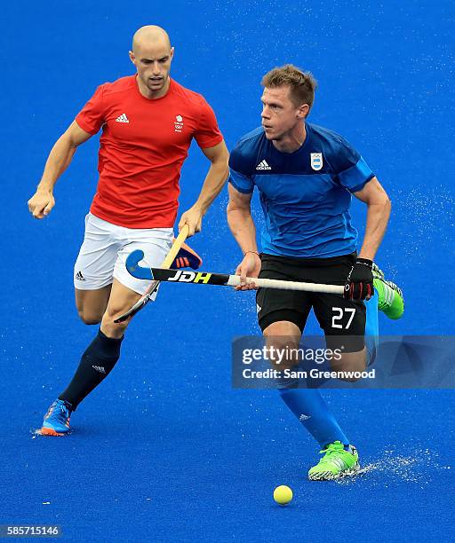 Lucas Rossi of Argentina runs past Nick Catlin of Great Britain during a training session in the Olympic Hockey Center on August 3, 2016 in Rio de...