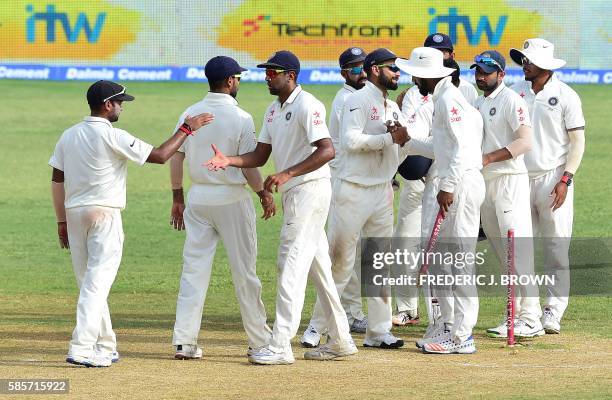 Players from India congratulate one another at the end of their match against the West Indies on day five of their Second Test cricket match on...