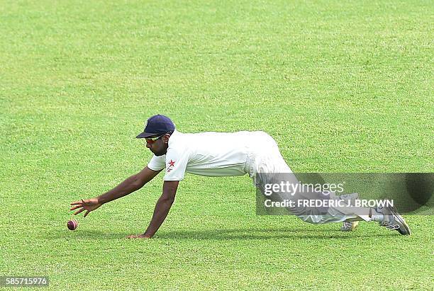 Ravichandran Ashwin dives but misses stopping the ball hit by Roston Chase of the West Indies off a delivery from bolwer Mohammed Shami on day five...
