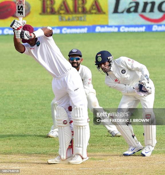 Roston Chase of the West Indies reacts off a delivery from bowler Amit Mishra of India wicket keeper Wriddhiman Saha and Cheteshwar Pujara play close...