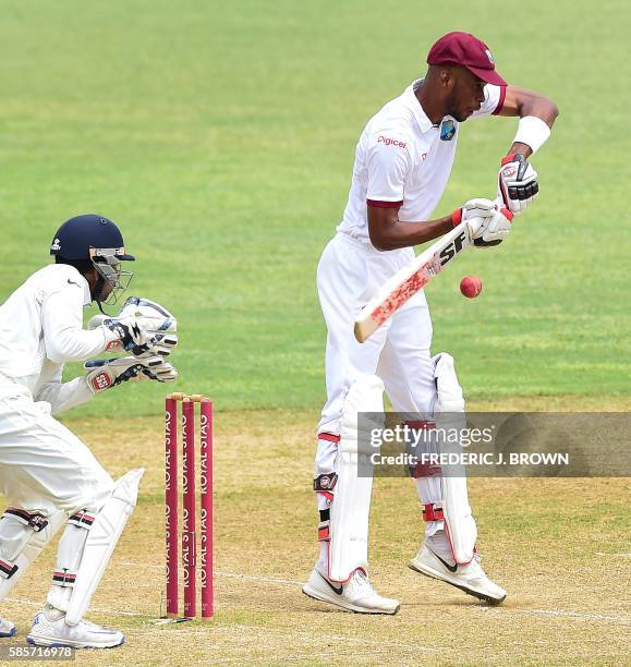 Roston Chase of the West Indies blocks the bouncer off a delivery from bowler Amit Mishra of India as wicket keeper Wriddhiman Saha plays close to...