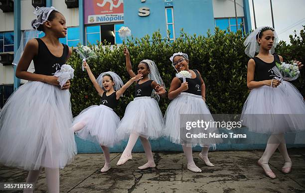 Dancers clown around while waiting to perform ahead of the arrival of the Olympic torch relay in Rio's North Zone on August 3, 2016 in Rio de...