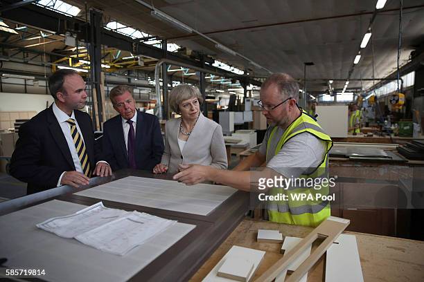 British Prime Minister Theresa May, Martek Managing Director Derek Galloway and Croydon Central MP Gavin Barwell speak with a worker as they visit...