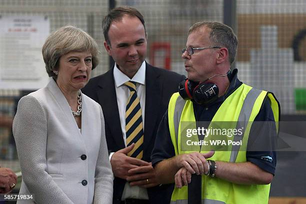 British Prime Minister Theresa May and Croydon Central MP Gavin Barwell speak with a worker as they visit Martinek joinery factory on August 3, 2016...