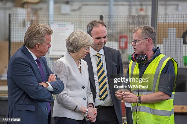 British Prime Minister Theresa May, Martek Managing Director Derek Galloway and Croydon Central MP Gavin Barwell speak with a worker as they visit...