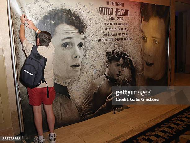 An attendee signs a memorial display for actor Anton Yelchin during the 15th annual official Star Trek convention at the Rio Hotel & Casino on August...