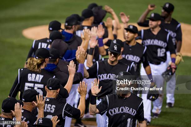 Charlie Blackmon of the Colorado Rockies celebrates a 12-2 win over rat Los Angeles Dodgers with Walt Weiss and others after a game at Coors Field on...