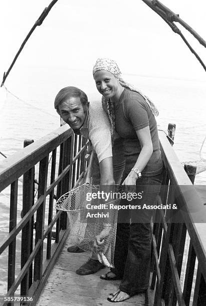 Italian TV host Pippo Baudo on holiday with his first wife Angela Lippi on a Roman coast beach. In the picture: the couple posing smiling on a jetty...