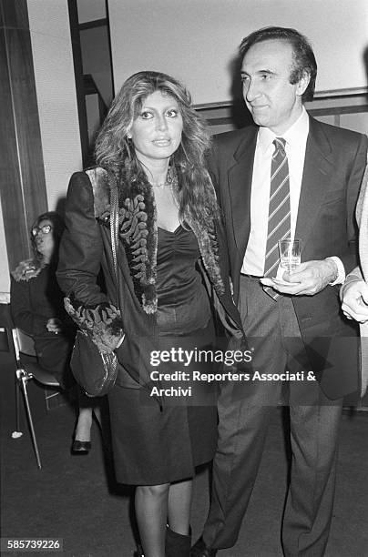 Italian TV host Pippo Baudo with his girlfriend, Italian singer and actress Alida Chelli , at a cocktail party. In the picture: the TV host mildly...